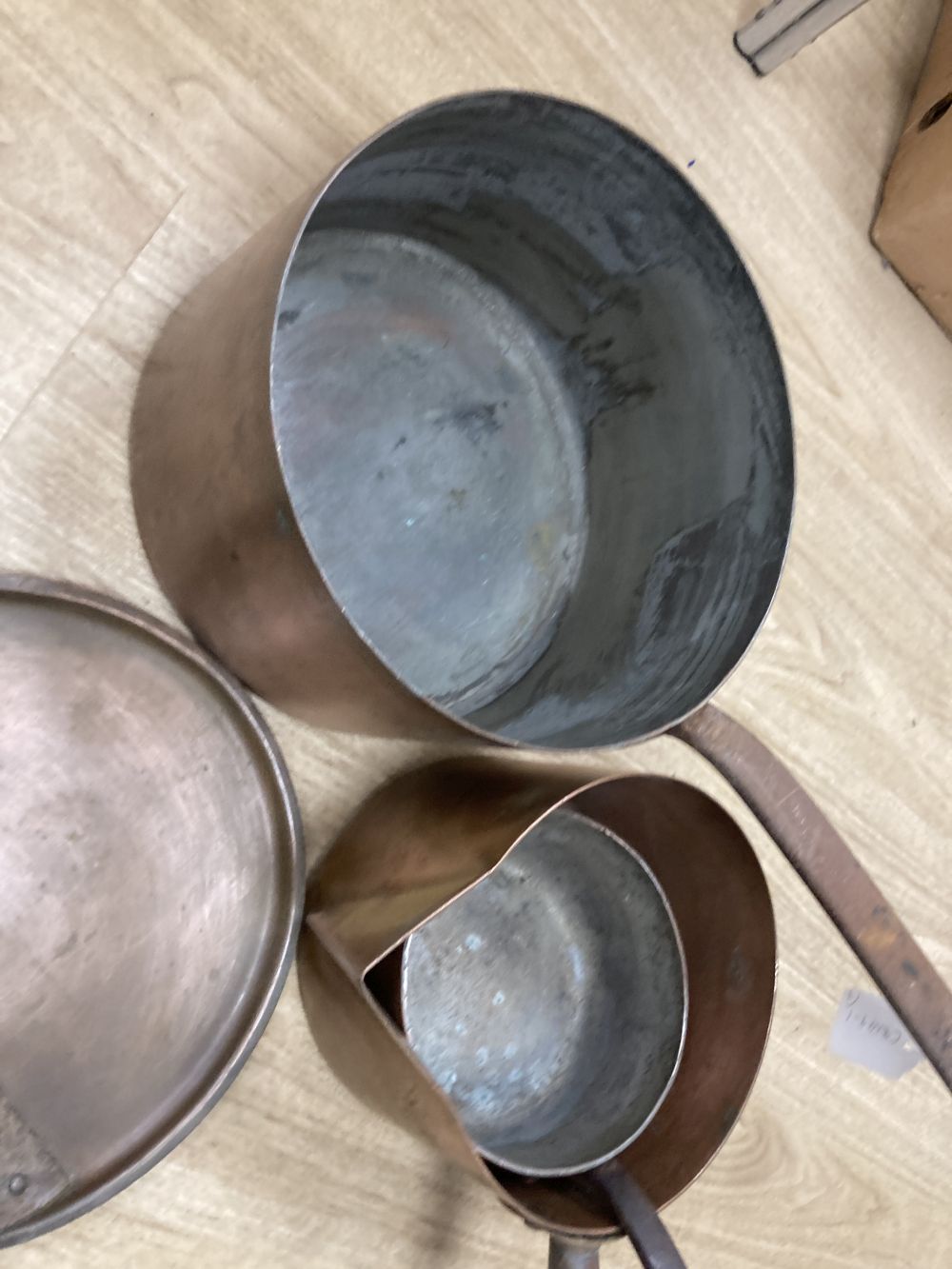 Three 19th century copper pans, one with lid, middle saucepan 27cm diameter